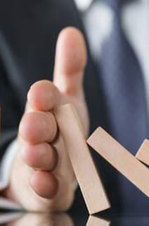 Osoba powstrzymująca klocki przed upadkiem na stół