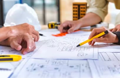 Close-up of people examining blueprints